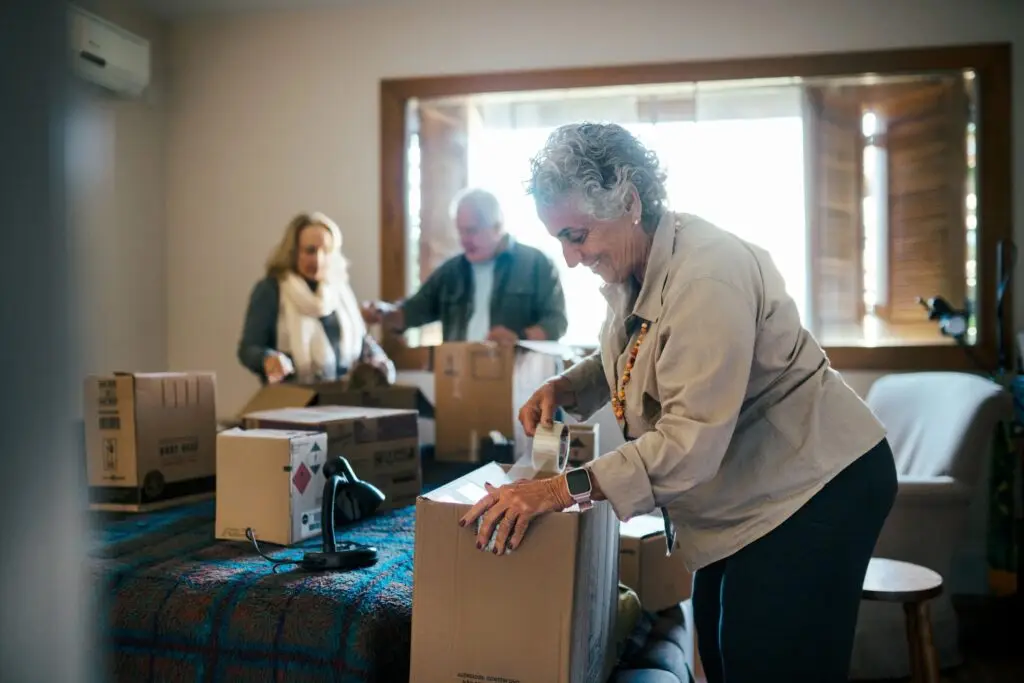 Group of senior friends unpacking boxes in the bedroom